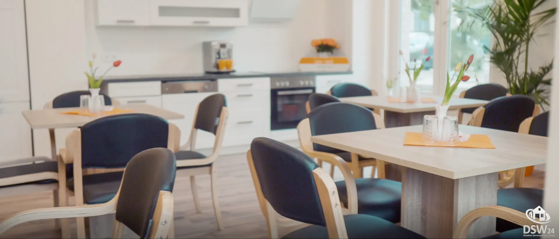 DSW24 – Dresder Servicewohnen GmbH – Wohnungsbeispiel – Gemeinschaftsraum Gemeinschaftsraum einer Residenz der DSW24 Dresdner Servicewohnen GmbH mit Küche, Tischen und Stühlen für Veranstaltungen und gemeinsame Aktivitäten.