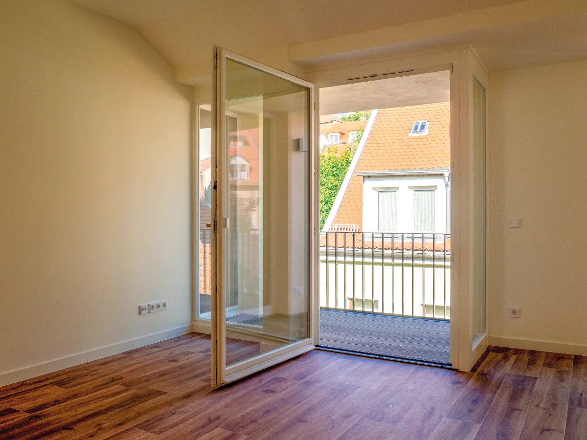 DSW24 – Dresder Servicewohnen GmbH – Laurentii Residenz Meißen – Balkon Zimmer der Laurentii Residenz in Meißen mit geöffneter Balkontür und Vinylboden.