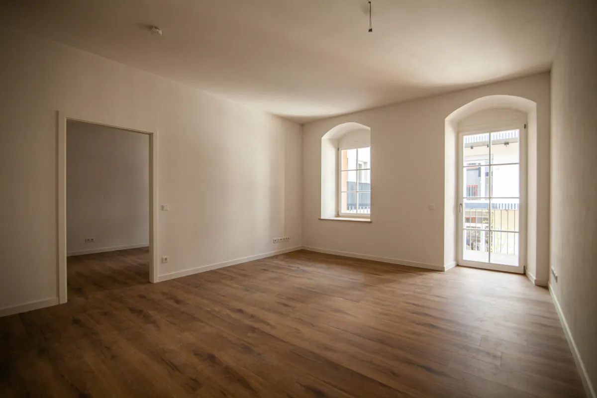 DSW24 – Dresder Servicewohnen GmbH – Laurentii Residenz Meißen – Wohnzimmer Wohnzimmer der Laurentii Residenz in Meißen mit Fenster, Balkontür und Vinylboden.