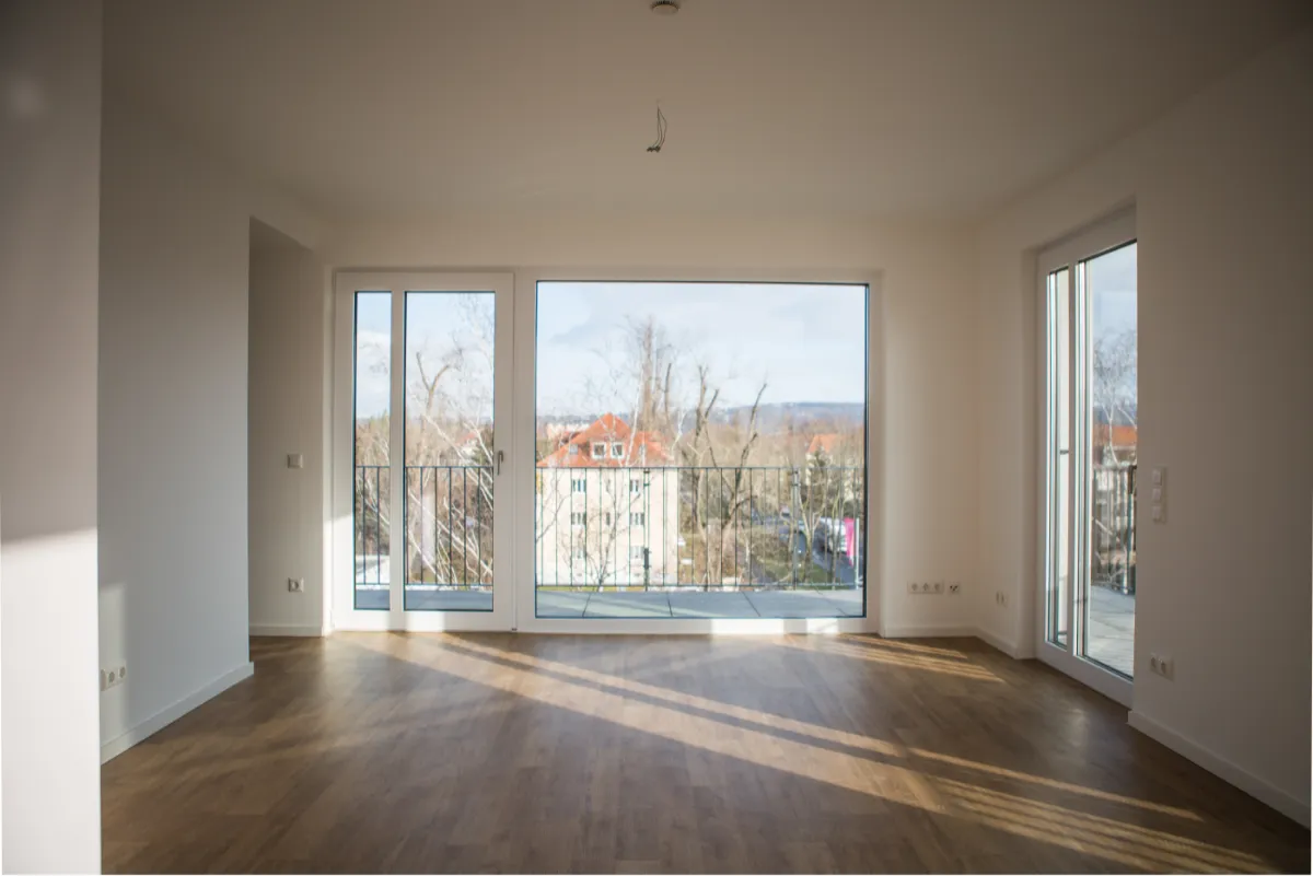 DSW24 – Dresder Servicewohnen GmbH – Rennbahn Residenz Dresden-Seidnitz – Wohnbereich mit großen Fenstern Heller Wohnbereich der Rennbahn Residenz in Dresden Seidnitz mit großen bodentiefen Fenstern und Balkonzugang.